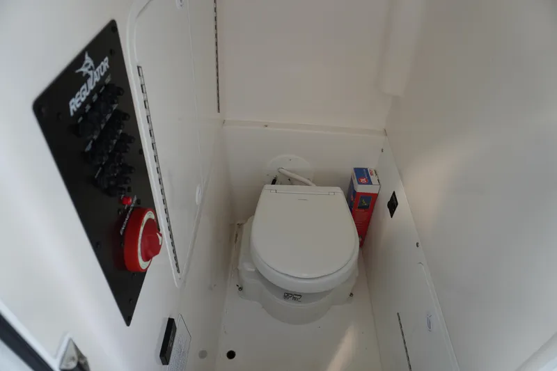 Slide: The Image of 2024 Regulator 26XO boat interior with toilet and control panel. - 38