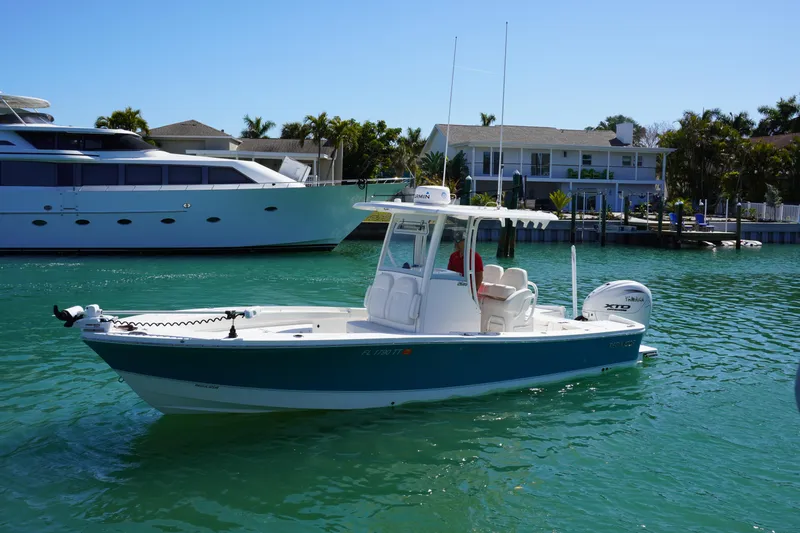 Slide: The Image of 2024 Regulator 26XO boat on turquoise water near luxury waterfront homes. - 4