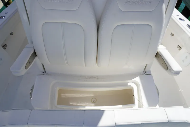 Slide: The Image of 2024 Regulator 26XO boat seating with storage compartment, featuring white cushioned seats. - 45