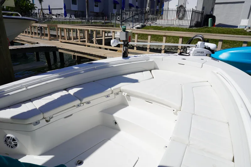 Slide: The Image of 2024 Regulator 26XO boat interior with white seating and dockside view. - 47