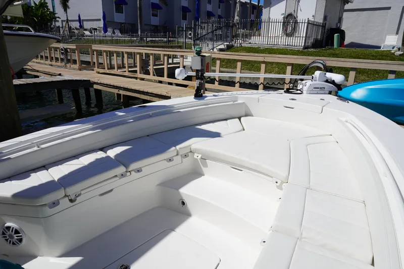 Slide: The Image of 2024 Regulator 26XO boat interior with white seating and dockside view. - 48