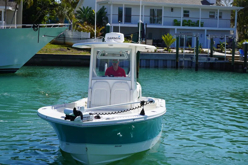 Slide: The Image of 2024 Regulator 26XO boat on turquoise water near a waterfront house. - 5