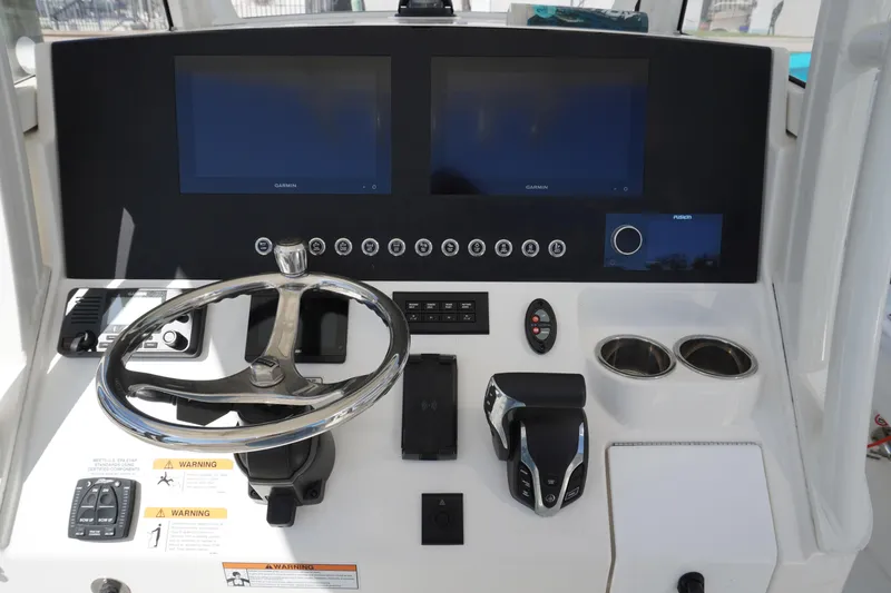 Slide: The Image of 2024 Regulator 26XO boat dashboard with dual screens and steering wheel. - 53