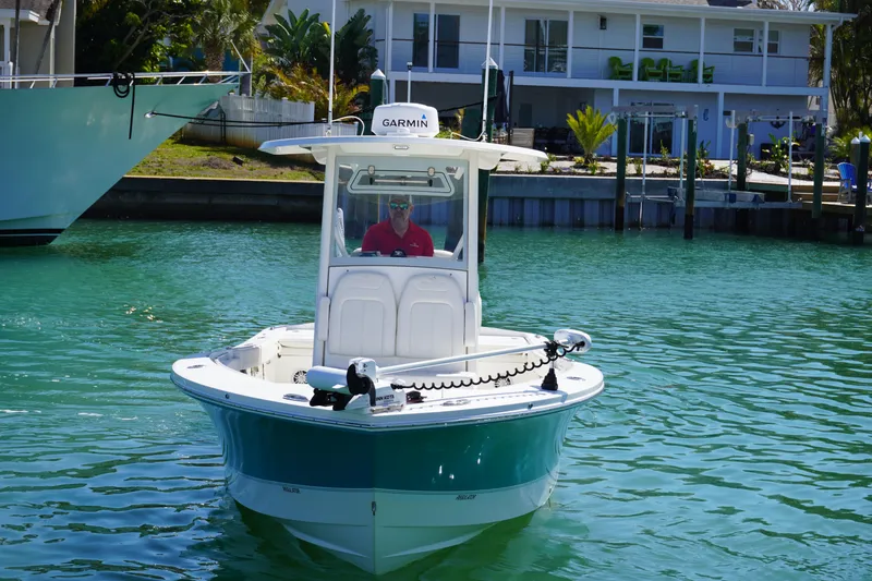 Slide: The Image of 2024 Regulator 26XO boat on water, featuring Garmin equipment, near a waterfront house. - 6