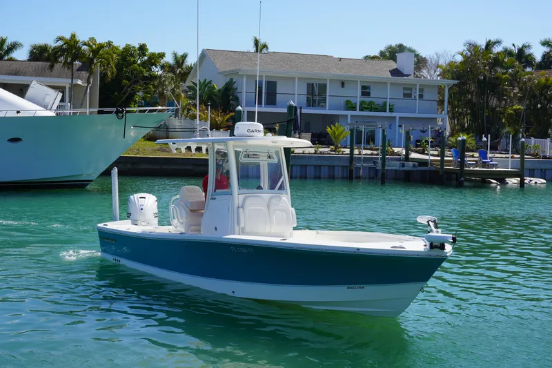 Slide: The Image of 2024 Regulator 26XO boat cruising in a sunny waterfront setting. - 7