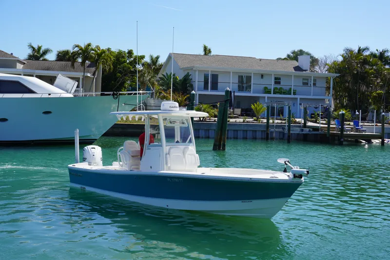 Slide: The Image of 2024 Regulator 26XO boat cruising in a sunny waterfront setting. - 8