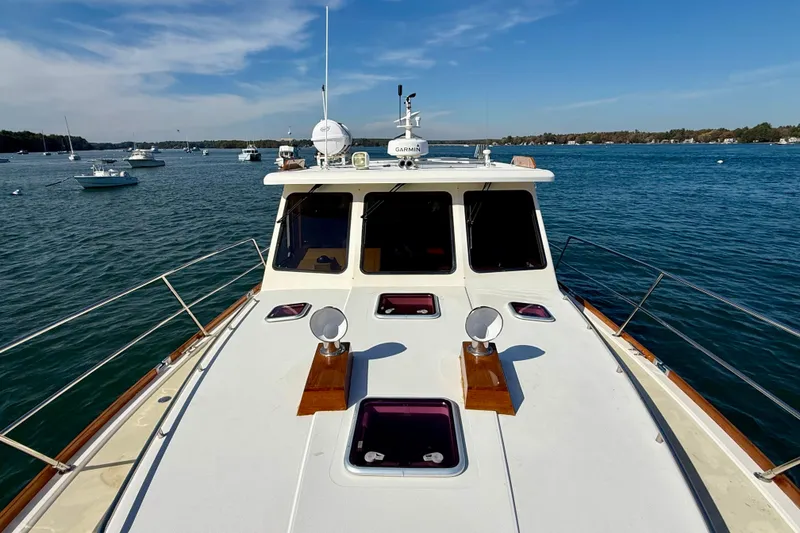 Slide: The Image of 2006 Sabre 42 Sedan yacht on calm water, clear sky, and distant boats. - 12
