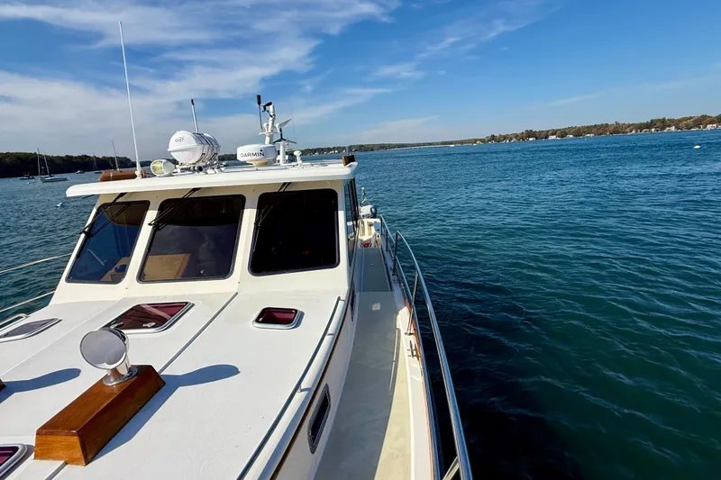 Slide: The Image of 2006 Sabre 42 Sedan cruising on a serene blue lake under a clear sky. - 13