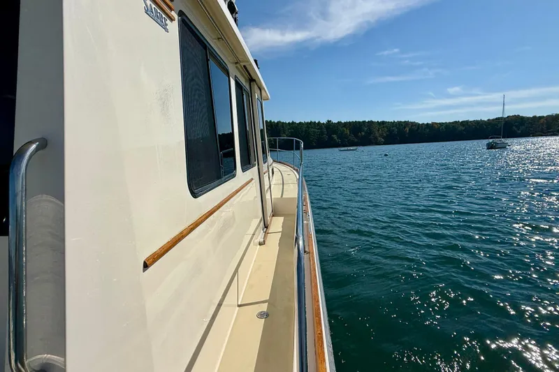 Slide: The Image of 2006 Sabre 42 Sedan yacht on serene lake with clear blue sky. - 19