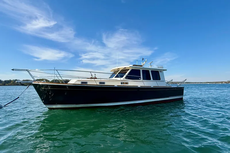 Slide: The Image of 2006 Sabre 42 Sedan boat on calm water under clear blue sky. - 2