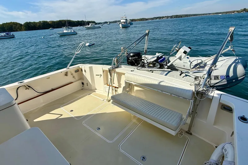 Slide: The Image of 2006 Sabre 42 Sedan yacht deck with seating, docked near other boats on a sunny day. - 20