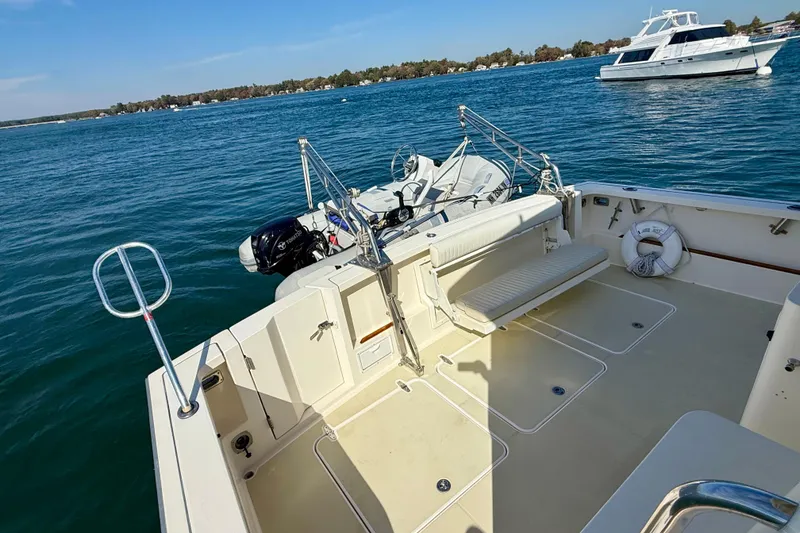 Slide: The Image of 2006 Sabre 42 Sedan boat deck with seating, docked on calm blue water. - 21
