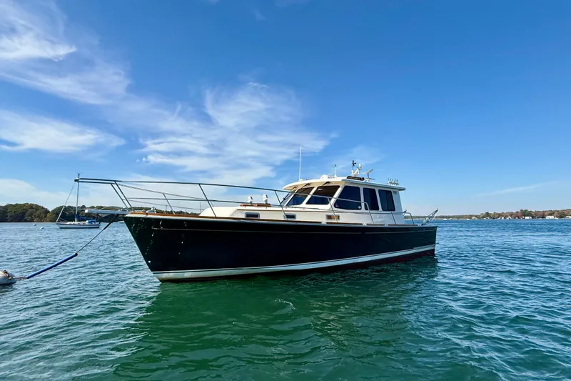 Slide: The Image of 2006 Sabre 42 Sedan yacht anchored on calm blue water under clear sky. - 3
