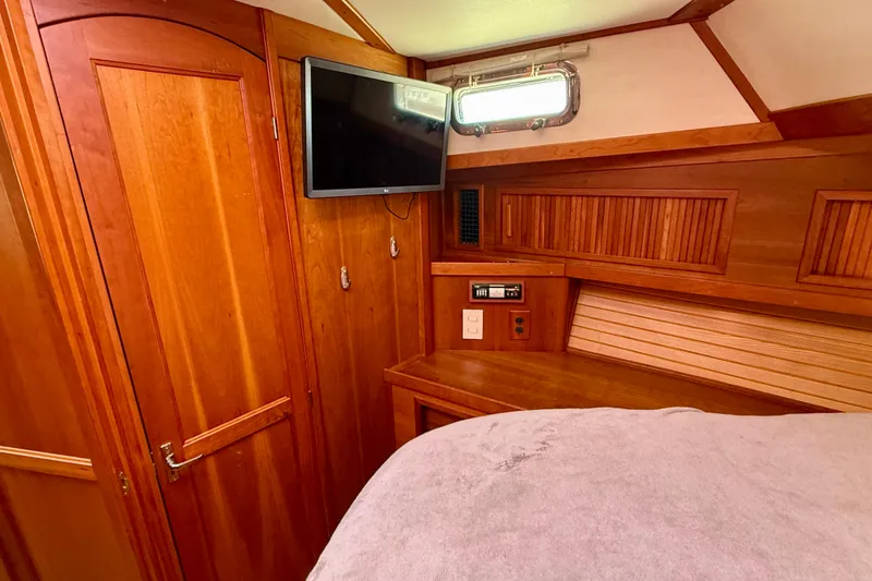 Slide: The Image of 2006 Sabre 42 Sedan cabin interior with wood paneling and mounted TV. - 31