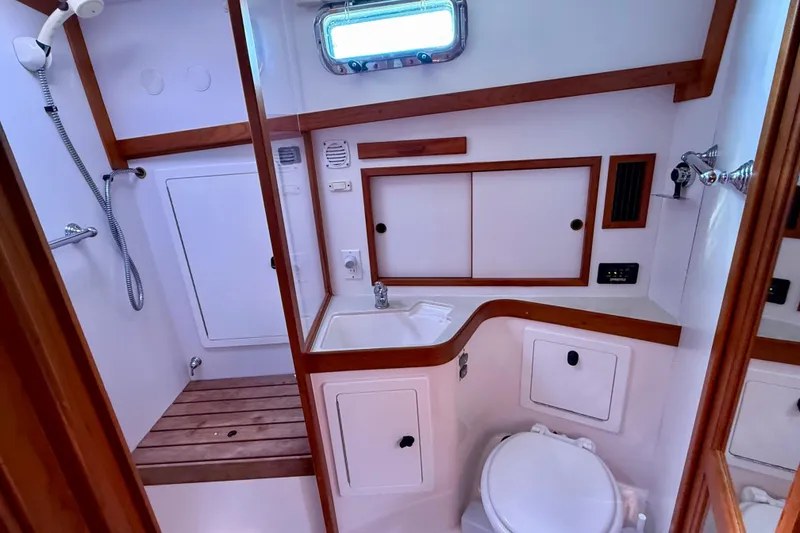 Slide: The Image of 2006 Sabre 42 Sedan bathroom with shower, sink, and toilet, featuring wood accents. - 34