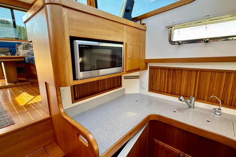 Slide: The Image of 2006 Sabre 42 Sedan galley with microwave, wooden cabinetry, and countertop. - 38