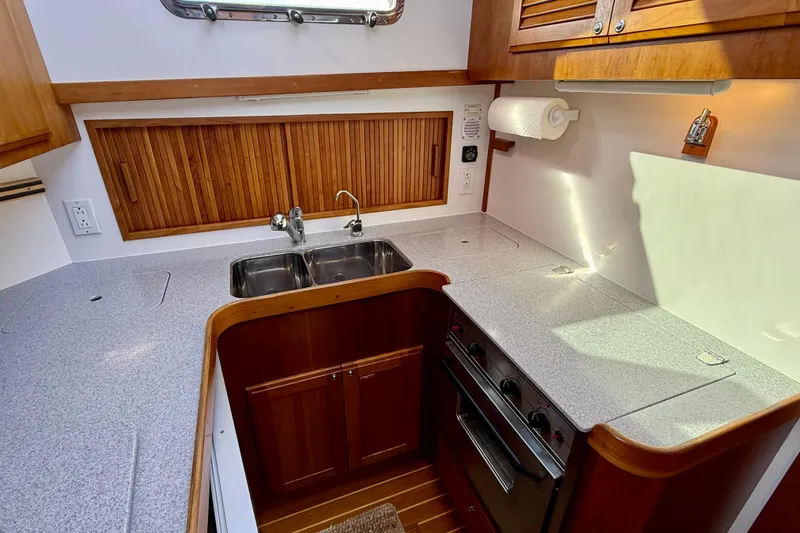 Slide: The Image of 2006 Sabre 42 Sedan kitchen with stainless steel sink, stove, and wooden cabinetry. - 39