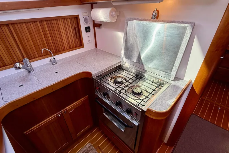 Slide: The Image of 2006 Sabre 42 Sedan kitchen with stove, sink, and wooden cabinetry. - 40