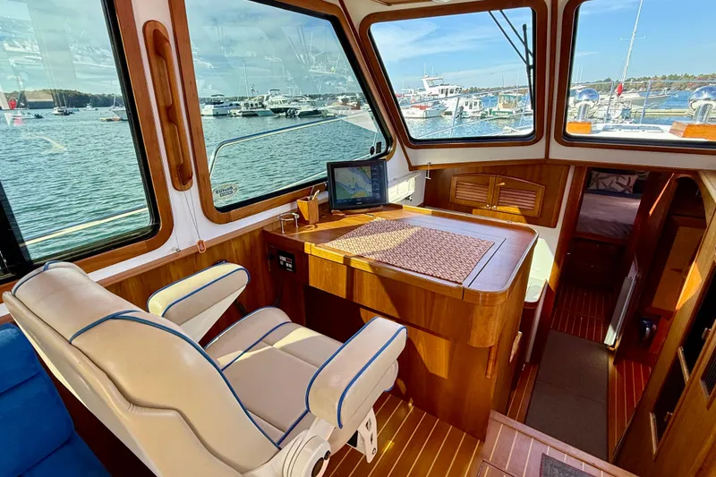 Slide: The Image of Interior of 2006 Sabre 42 Sedan yacht with helm, seating, and scenic marina view. - 42