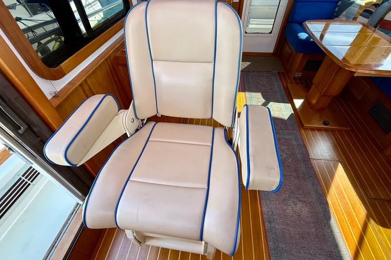 Slide: The Image of Captain's chair in 2006 Sabre 42 Sedan, featuring white upholstery with blue trim. - 52