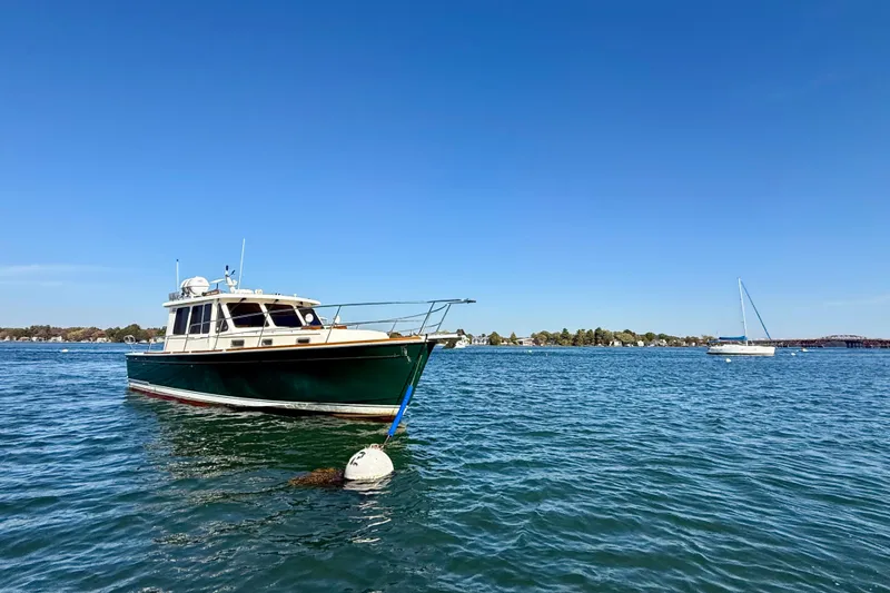 Slide: The Image of 2006 Sabre 42 Sedan boat anchored on calm blue water under clear sky. - 6