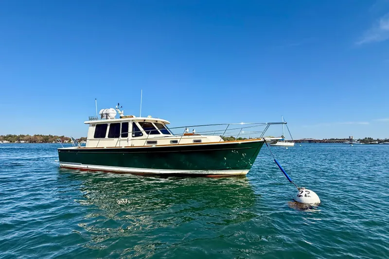 Slide: The Image of 2006 Sabre 42 Sedan boat anchored on calm water under clear blue sky. - 7
