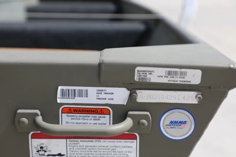 Slide: The Image of 2025 Tracker Grizzly 1436 Jon boat with warning labels and certification sticker. - 9