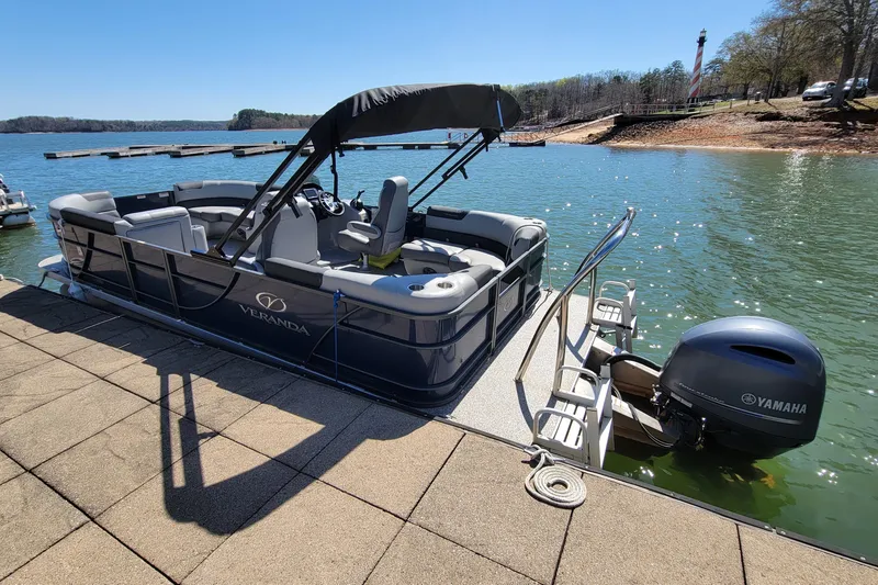 Slide: The Image of Pontoon boat Veranda Relax VR20RC 2023 docked by a scenic lake. - 2