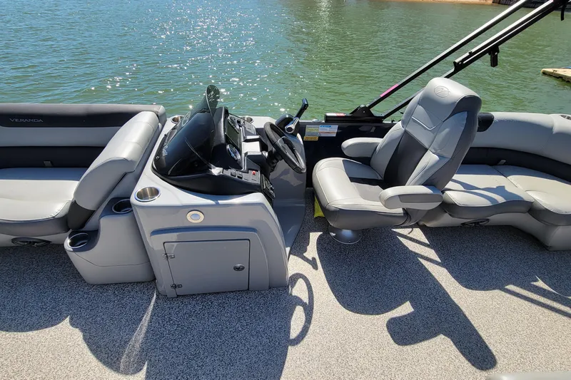 Slide: The Image of 2023 Veranda Relax VR20RC pontoon boat interior with steering console and seating. - 4