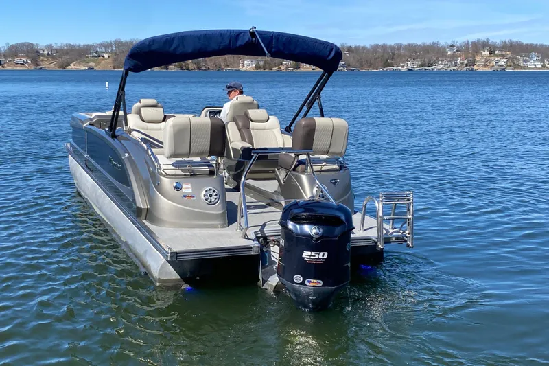 Slide: The Image of 2016 Manitou 25 Legacy LT SHP pontoon boat on a serene lake. - 10