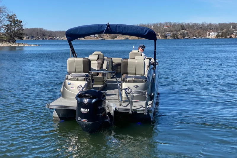 Slide: The Image of 2016 Manitou 25 Legacy LT SHP pontoon boat on a serene lake. - 11