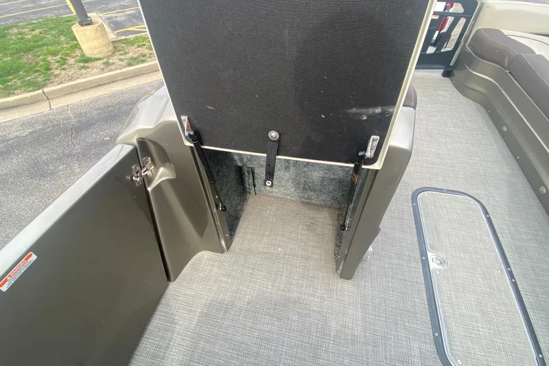 Slide: The Image of 2016 Manitou 25 Legacy LT SHP boat interior with open storage compartment. - 17