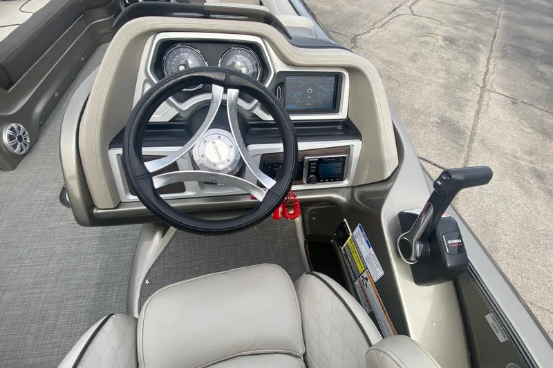 Slide: The Image of 2016 Manitou 25 Legacy LT SHP boat dashboard with steering wheel and controls. - 21