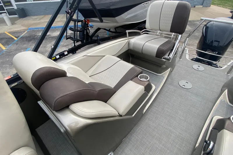 Slide: The Image of 2016 Manitou 25 Legacy LT SHP boat interior with plush seating and cup holders. - 27