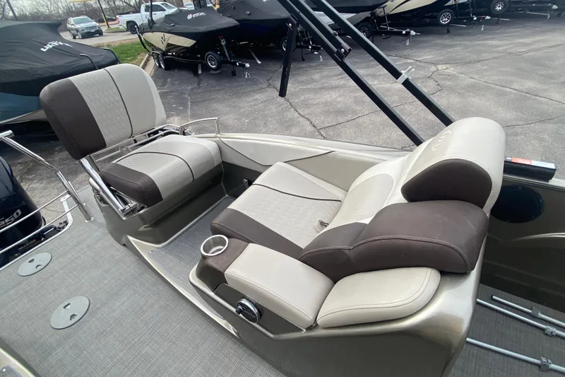 Slide: The Image of 2016 Manitou 25 Legacy LT SHP boat interior with comfortable seating and cup holder. - 28