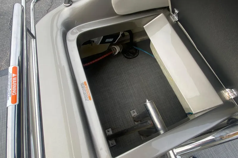 Slide: The Image of Storage compartment of 2016 Manitou 25 Legacy LT SHP boat, featuring warning labels. - 33