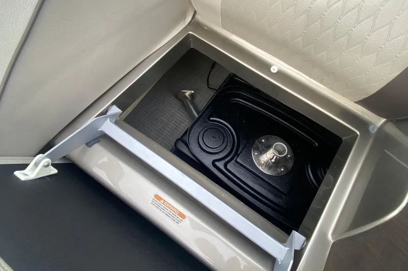 Slide: The Image of Storage compartment in 2016 Manitou 25 Legacy LT SHP boat, featuring secure latch and durable interior. - 34