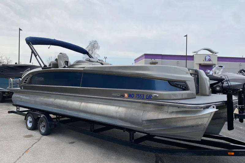 Slide: The Image of 2016 Manitou 25 Legacy LT SHP pontoon boat on trailer, parked outdoors. - 42
