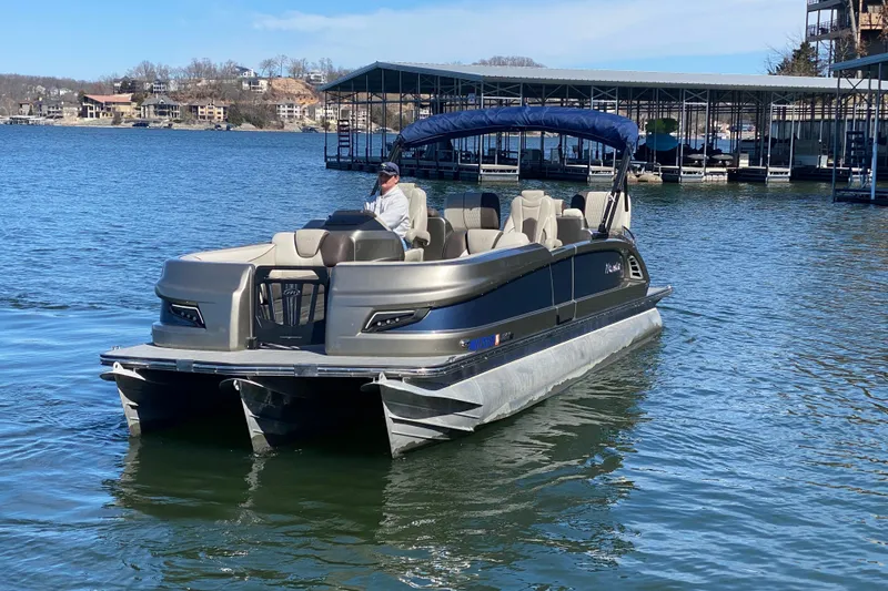 Slide: The Image of 2016 Manitou 25 Legacy LT SHP pontoon boat on a lake with a covered dock. - 5
