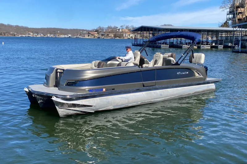 Slide: The Image of 2016 Manitou 25 Legacy LT SHP pontoon boat on a lake with a blue canopy. - 6