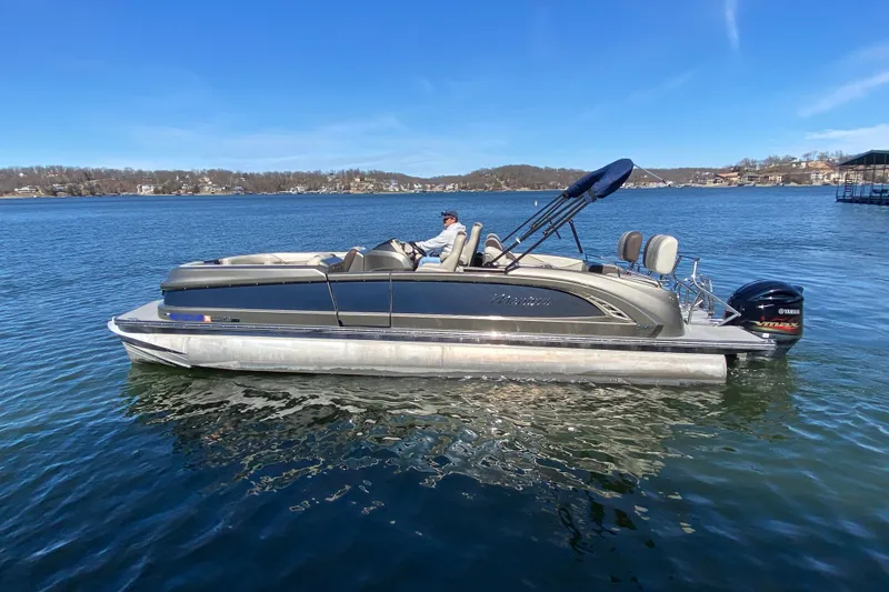 Slide: The Image of 2016 Manitou 25 Legacy LT SHP pontoon boat on a calm lake. - 7