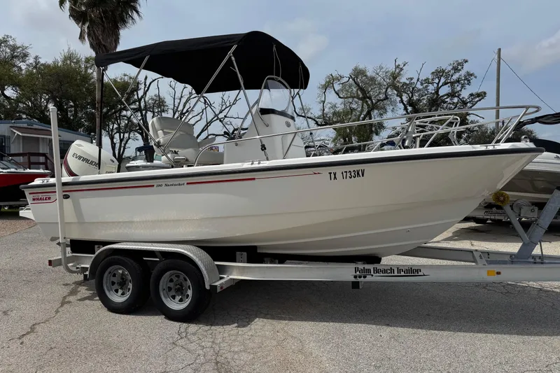 The Image of 2004 Boston Whaler 190 Nantucket boat on trailer, parked outdoors. - 0