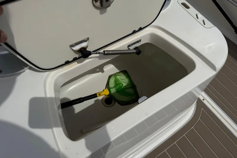 Slide: The Image of Open storage compartment on 2004 Boston Whaler 190 Nantucket boat with a green net inside. - 14