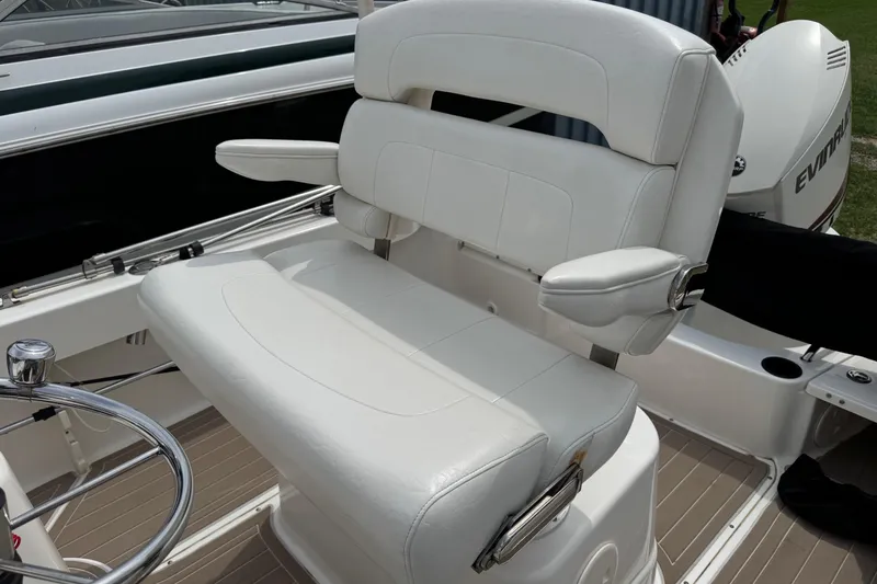 Slide: The Image of 2004 Boston Whaler 190 Nantucket boat seat with white upholstery and armrests. - 16