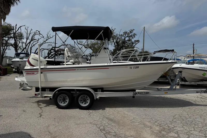 Slide: The Image of 2004 Boston Whaler 190 Nantucket boat on trailer, parked outdoors under cloudy sky. - 19
