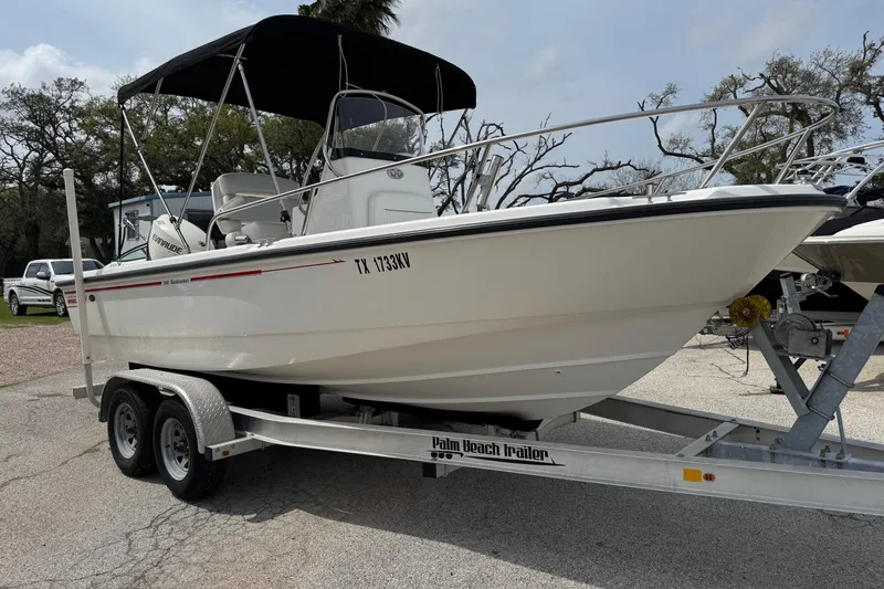 Slide: The Image of 2004 Boston Whaler 190 Nantucket boat on trailer with canopy, parked outdoors. - 20