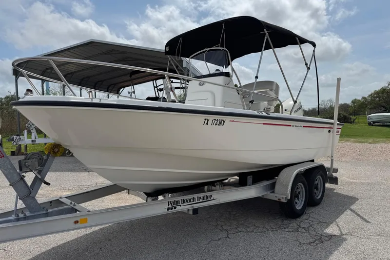 Slide: The Image of 2004 Boston Whaler 190 Nantucket boat on trailer, parked outdoors under cloudy sky. - 21