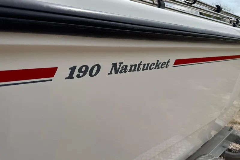 Slide: The Image of 2004 Boston Whaler 190 Nantucket boat side view with red stripe detailing. - 3