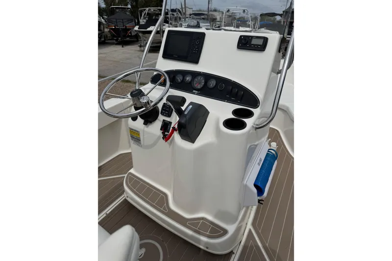 Slide: The Image of 2004 Boston Whaler 190 Nantucket boat console with steering wheel and navigation controls. - 6