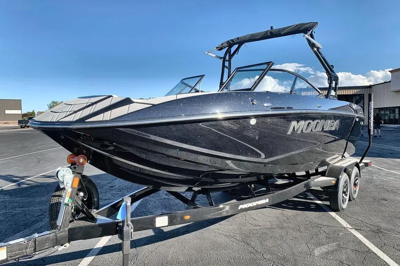 The Image of 2026 Moomba Mojo boat on trailer in parking lot, sunny day. - 1